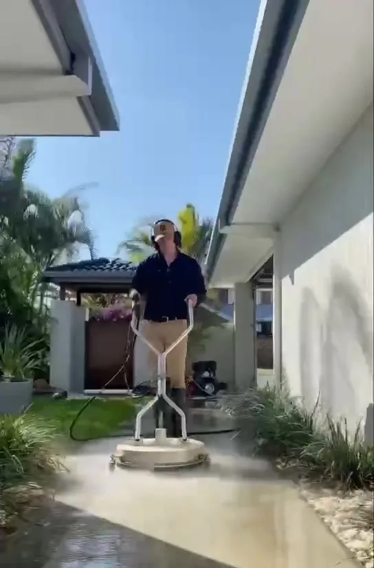 Pressure washing a driveway between Gold Coast homes